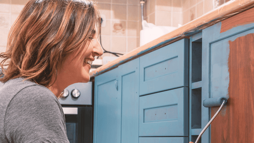 Ein Mann streicht seine alte Küche.