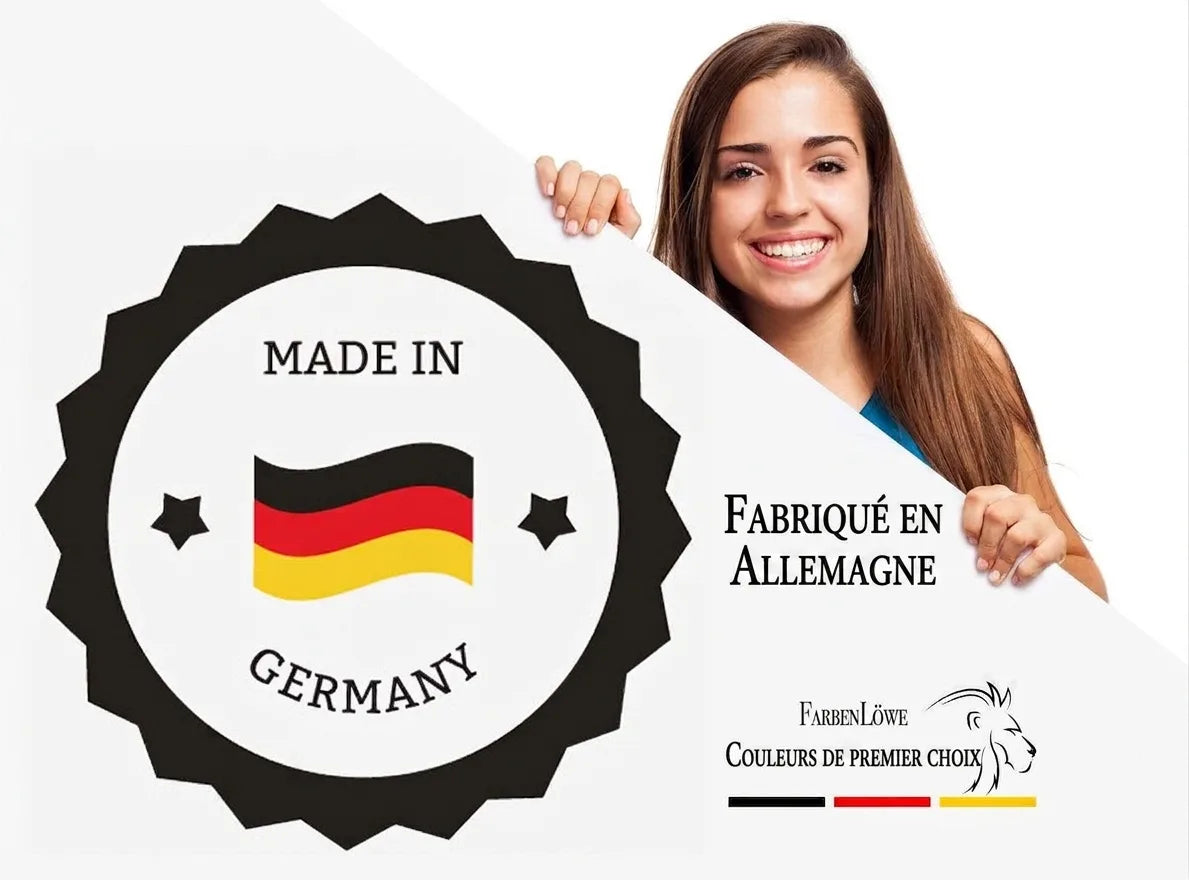 Femme souriante tenant une affiche avec un badge 'Made in Germany' et le logo 'FarbenLöwe Farben DER KÖNIGSKLASSE'.