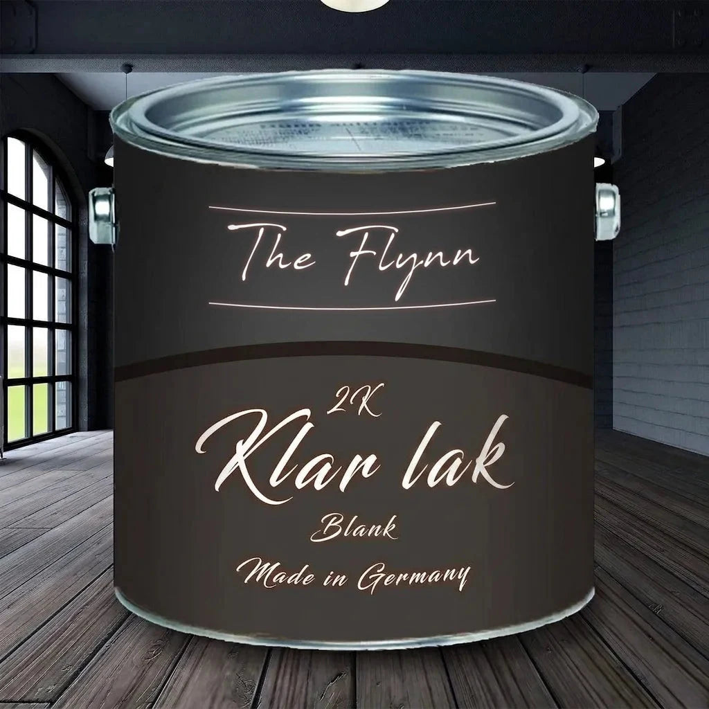 Sort malingsdåse med teksten 'The Flynn 2K Klarlack Glänzend Made in Germany' på trægulv.