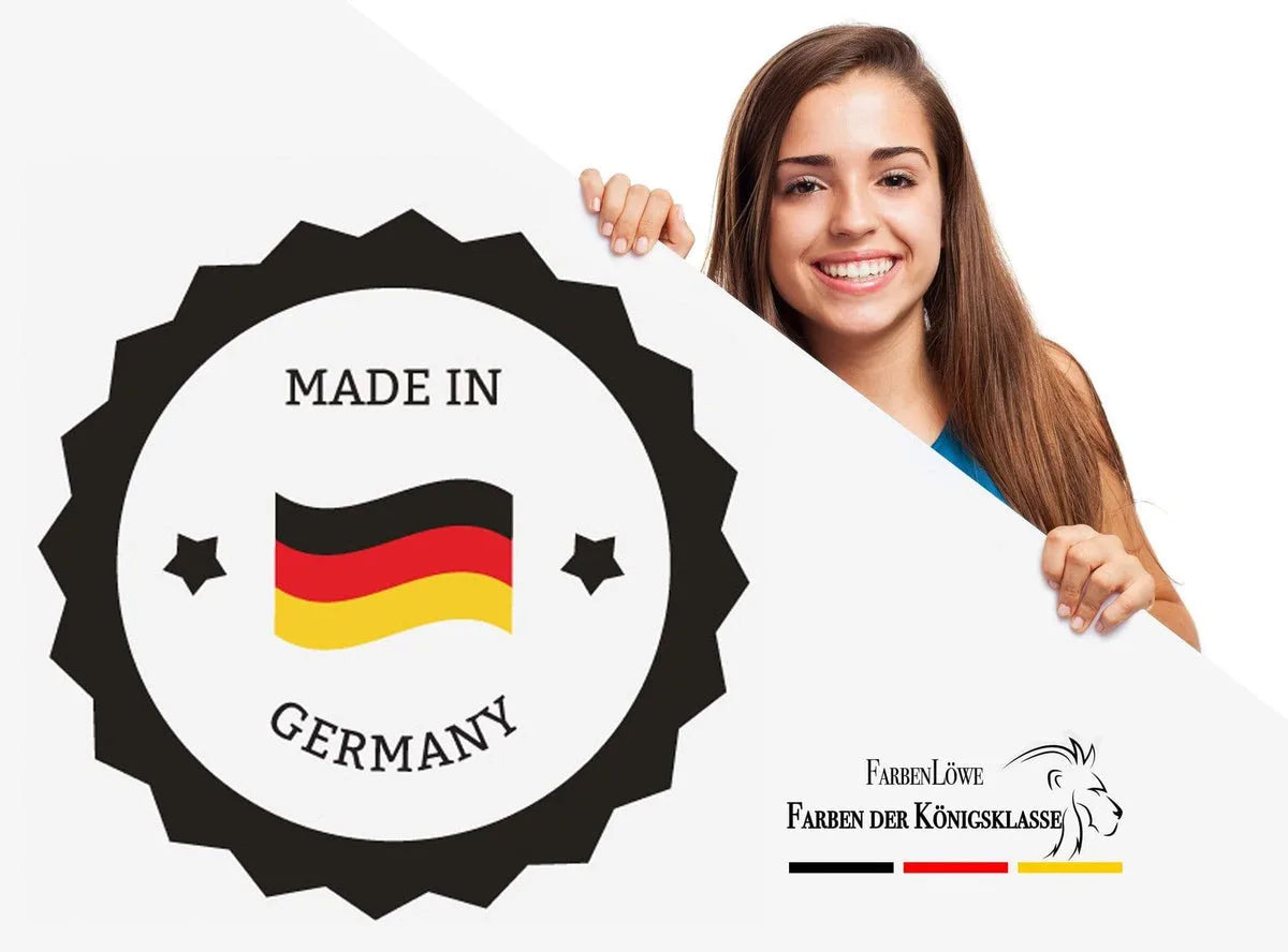 Młoda, uśmiechnięta kobieta trzyma białą tablicę z plakietką „Made in Germany” i logo marki FarbenLöwe.