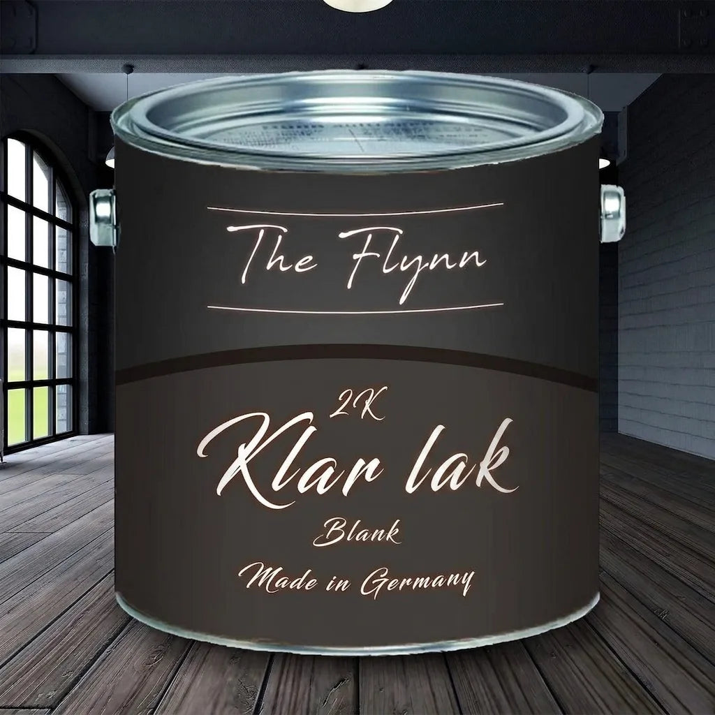 Sort malingsdåse med teksten 'The Flynn 2K Klarlack Glänzend Made in Germany' på trægulv.